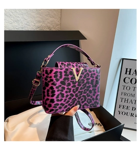 Detail of purple leopard print box bag with V-shaped metal buckle on a silk fabric