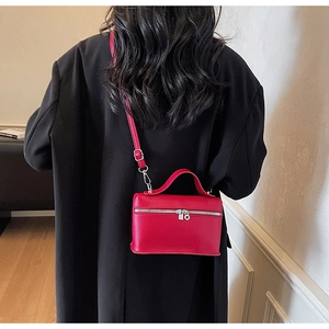 Vue de dos d'un mannequin portant le petit sac carré rouge en bandoulière sur un manteau noir