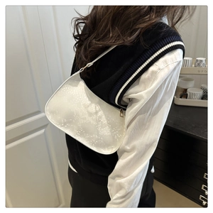 Side view of white snakeskin hobo bag on shoulder featuring gold zipper and chic texture