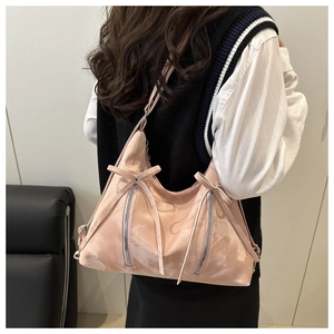 Detail der rosa Schultertasche mit süßen Schleifen und dekorativen Reißverschlüssen