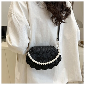 Detail of snake-embossed shell bag with elegant pearl handle and metal lock