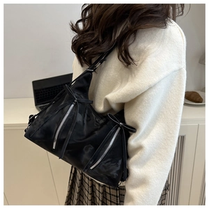 Modell mit schwarzer Hobo-Tasche mit Schleifen und silbernen Reißverschlüssen