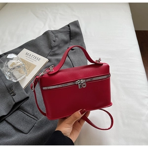 Détail du mini sac rouge foncé en cuir grainé avec finitions argentées et poignée