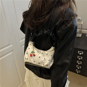 White hobo shoulder bag with black floral embroidery and cute cherry pendant accessory