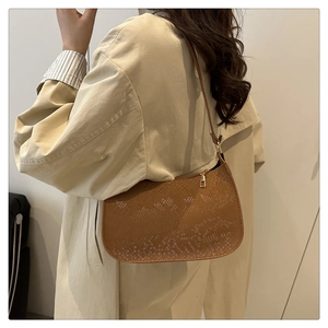 Close-up of brown animal skin texture shoulder bag worn with a beige trench coat