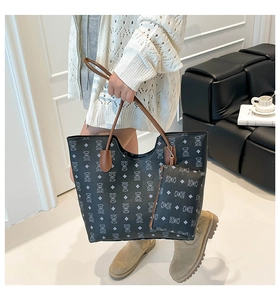 Détail du sac cabas noir à motif d'ours avec poignées brunes et une petite pochette assortie