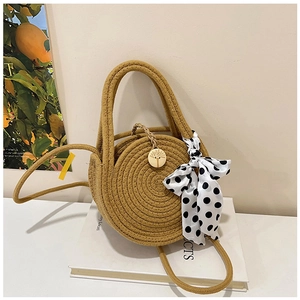 Detail der gewebten Strohtasche mit gepunktetem Schal und Holzknopf-Verzierung