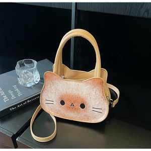 Détail d'un sac bandoulière en forme de chat avec imprimé toast sur bois sombre