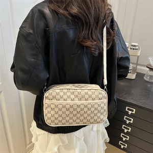 Minimalist beige crossbody bag with M-letter jacquard pattern for women on model