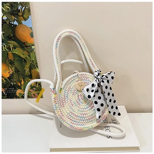 Detail einer runden Strohtasche mit farbigen Nähten und gepunkteter Schleife
