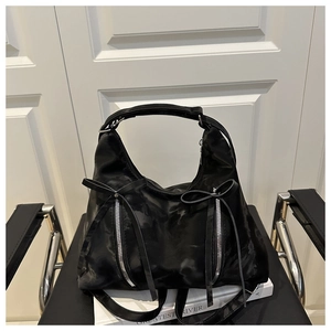 Detail der schwarzen Hobo-Tasche mit Silber-Reißverschlüssen und eleganten Schleifen