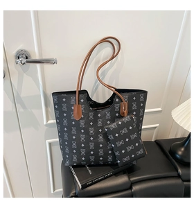 Détail du sac cabas noir avec motif ours et poignées contrastées en marron élégant