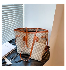 Dettaglio della borsa shopper a scacchi con finiture in pelle arancione e rivetti