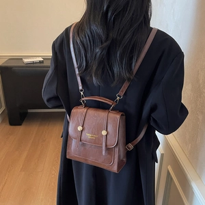 Vintage brown leather backpack for women featuring gold hardware and minimalist design