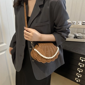 Brown shell bag with snake pattern texture and pearl chain decoration worn by model