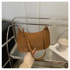 Detail of brown snakeskin texture on a crescent shoulder bag with gold hardware