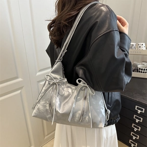 Silver metallic shoulder tote bag with bow detail and zippers in a trendy Y2K fashion style