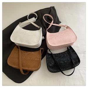 Detail of four retro snake-patterned underarm bags in white, pink, brown, and black