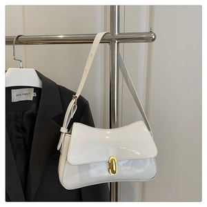 Detail of glossy white patent leather baguette bag with elegant golden oval metal buckle