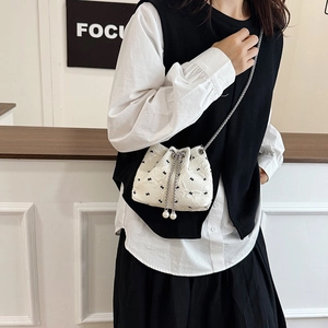 White jacquard bucket bag with black bow embroidery and pearl drawstring chain strap