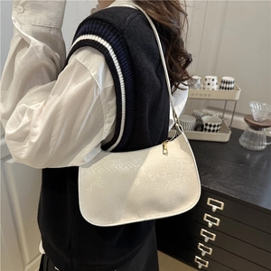 Minimalist white faux snakeskin shoulder bag for women shown in a modern home setting