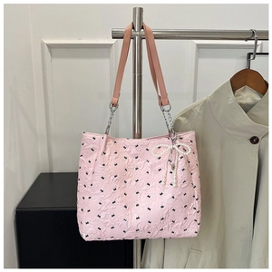 Détails du sac cabas rose avec motifs de nœuds, fleurs et pendentif en perles