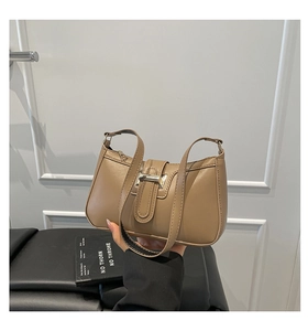 Detail of light brown leather underarm bag featuring a stylish silver square metal buckle