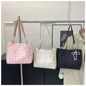 Détail de cabas rose, blanc et noir avec nœuds en perles et texture plissée élégante