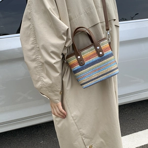 Rainbow striped straw bucket bag with brown leather handles and adjustable shoulder strap