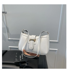 Close-up of a white leather shoulder bag featuring a rectangular gold metal buckle detail