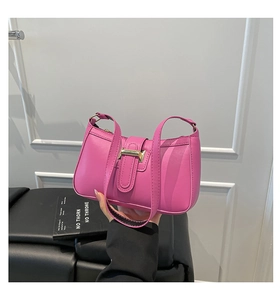 Detail of fuchsia shoulder bag featuring structured design and gold metal buckle hardware
