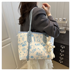 Détail du sac cabas en toile avec imprimés graffitis bleus et charmant lapin en peluche