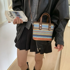 Colorful striped woven bucket bag with leather handles and crossbody strap