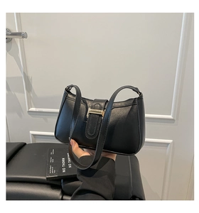 Close-up of black PU leather baguette bag featuring a gold rectangular buckle detail
