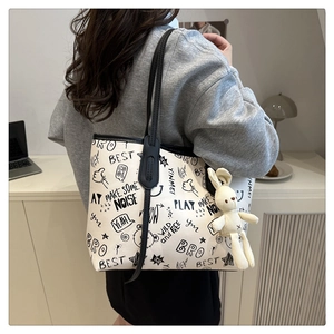 Détail du sac cabas à imprimé graffiti avec breloque lapin et fines anses noires