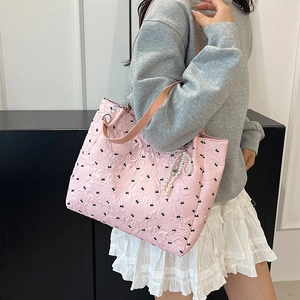 Sac cabas rose gaufré avec breloques perles porté à l'épaule pour un style automne