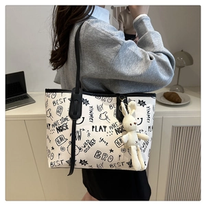 Détail du grand sac cabas blanc avec imprimés graffiti et charme lapin en peluche