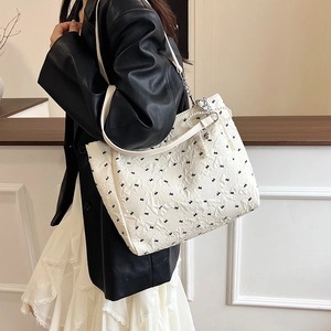 Sac fourre-tout matelassé blanc avec nœuds noirs, chaîne argentée et perle élégant