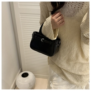 Détail d'un sac bandoulière en cuir noir minimaliste avec fine boucle métallique