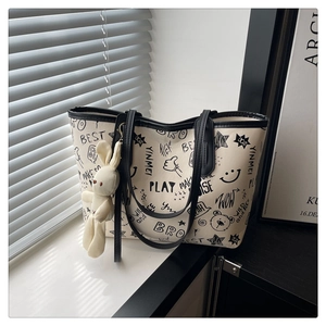 Détail du sac cabas avec imprimé graffiti noir et breloque lapin en peluche mignonne