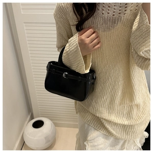 Détail d'un petit sac carré noir vintage avec finition en cuir lisse et boucle argentée