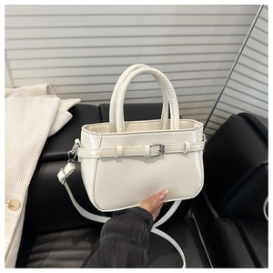 Détail d'un sac bandoulière carré crème avec boucle argentée et cuir PU texturé de qualité