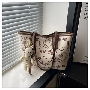 Détail du sac cabas avec imprimés cartoon mignons et son pendentif lapin en peluche