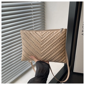 Detail of khaki V-quilted shoulder bag with black studs and smooth metal zipper