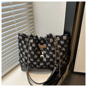 Détail du sac cabas en toile à damier avec bords effilochés et pendentif cerf doré