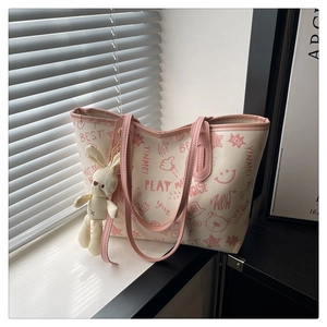 Détail du sac fourre-tout crème avec graffitis roses et charmant pendentif lapin en peluche