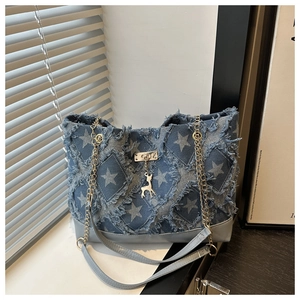Détail du cabas en jean avec motifs étoiles effilochés et bandoulière dorée