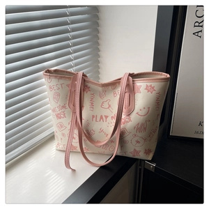 Gros plan sur les motifs graffiti roses et l'imprimé ours du grand sac cabas crème