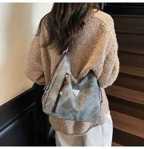 Détail du sac cabas gris en cuir vintage avec fermeture éclair verticale et plaque en métal