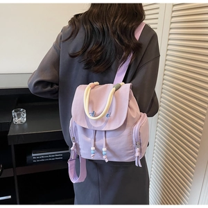 Lavender nylon backpack detail showing thick rope handle and blue Aibei embroidery